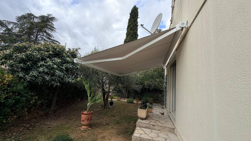 Store de terrasse motorisé de couleur beige avec toile 